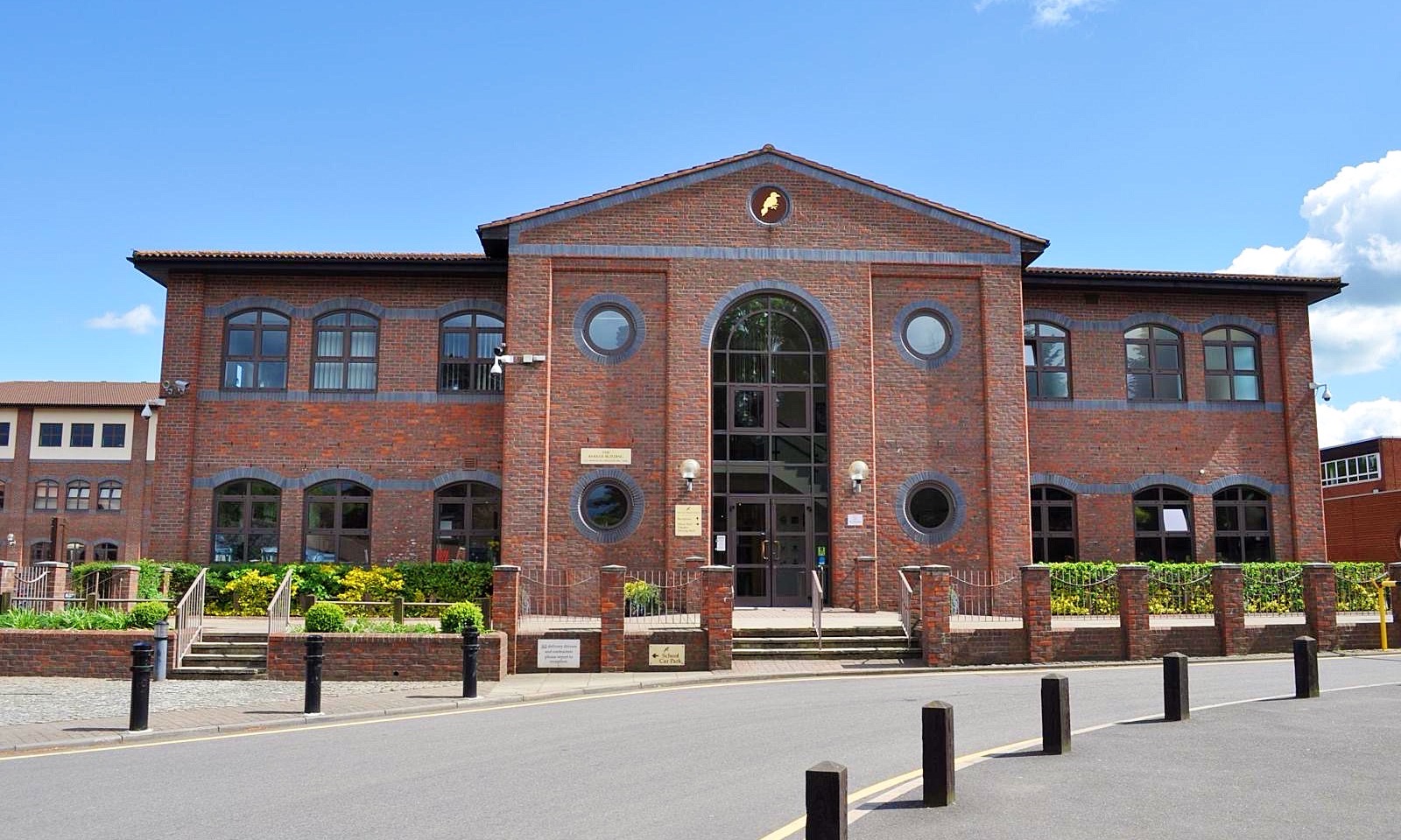 The red-brick Queen's Square School building, with arched windows and a central arched entrance